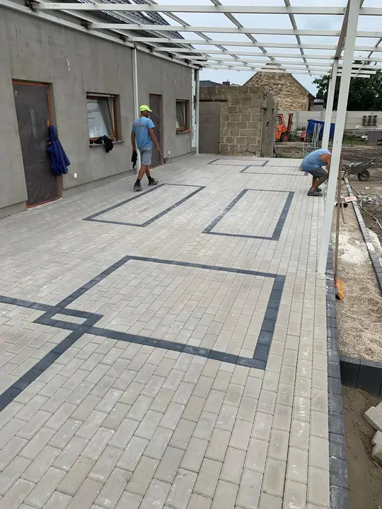 Duży plac z jasnej kostki brukowej z geometrycznym wzorem z grafitowej kostki