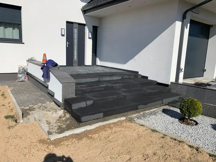 Antracytowe schody wejściowe ze stopni blokowych przed domem